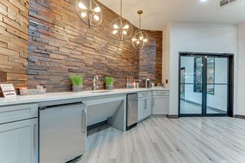 A modern kitchen with a wooden wall and stainless steel appliances.